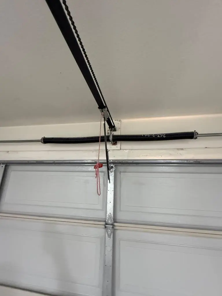 Professional inspection being done for Garage Door Spring Repair on residential door system